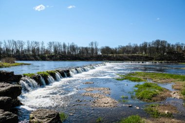 Kuldiga, Letonya - 1 Mayıs 2021: Kuldiga, Letonya 'da nehir, tarihi tuğla köprü ve Venta Nehri manzarası