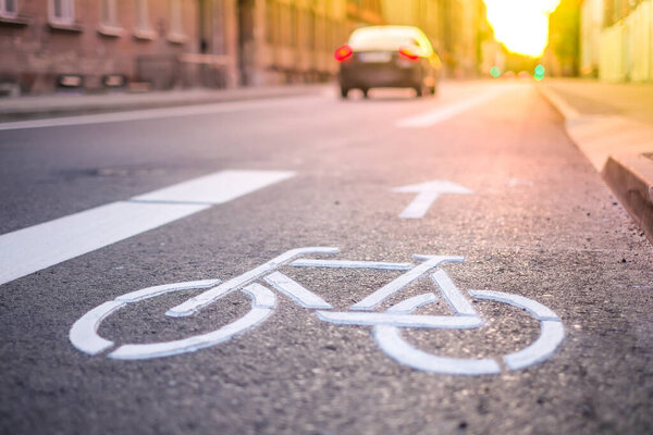 Separate bicycle lane for riding bicycles. A white bicycle symbol on the road. Selective focus
