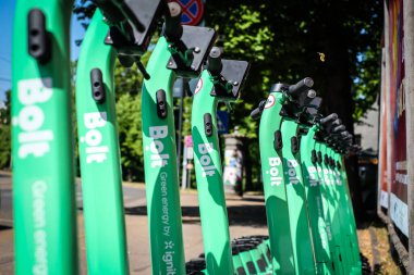 Riga, Latvia - July 18, 2022: Bolt electric rental scooters are parked on a sidewalk in Riga. Defocused