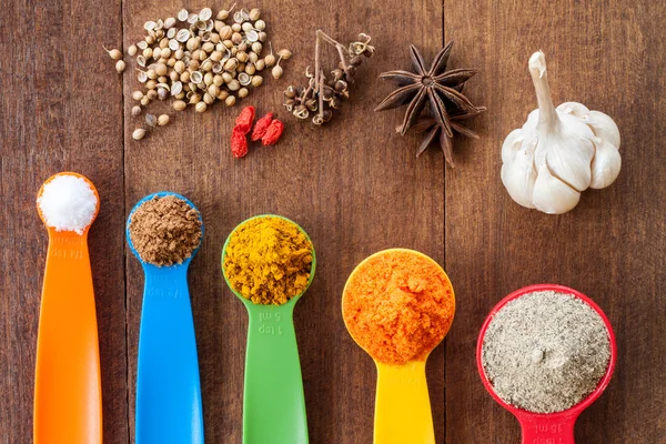 Various colorful spices on wooden table — Stock Photo, Image