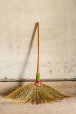 eski gri duvara yaslanmış süpürge