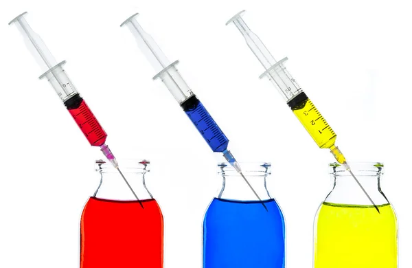 Kleurrijke water in glazen fles en spuit — Stockfoto