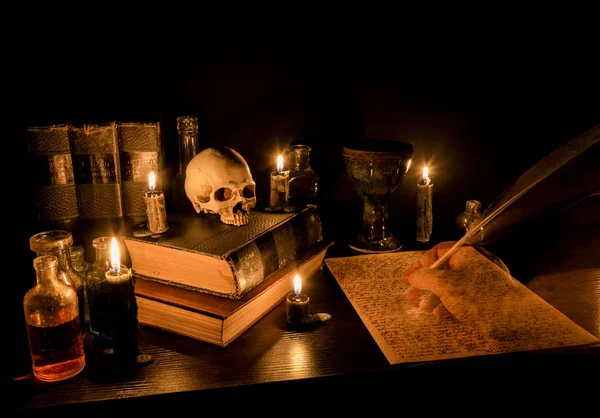 마법사의 책상이야 책상에 촛불을 사람의 두개골 물병등이 유령같은 깃대가 양피지에 — 스톡 사진