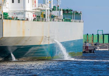 Tanker limana safra boşaltıyor. Yandan su akıyor. Gemi tanımlanamıyor. Geminin sadece bir kısmı görünüyor..