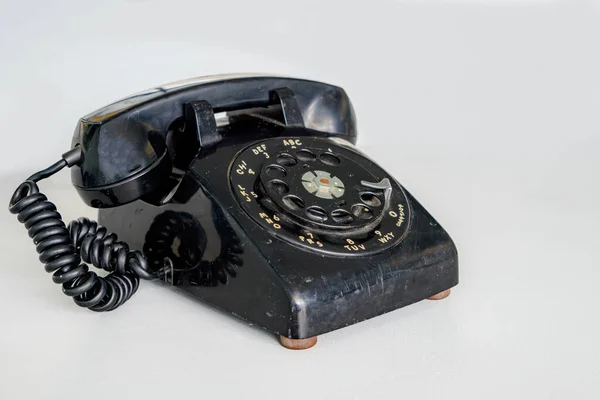 一个旧的黑色旋转拨号电话 它使用得很好 有轻微的划伤 并显示出污迹 英国背景 地底浅层 — 图库照片