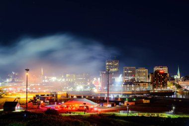 Saint John, NB, Kanada - 1 Ağustos 2021: Havai fişek gösterisi sonrası şehrin üzerinde büyük bir duman bulutu. Bulut şehirden gelen ışıkla parlıyor..