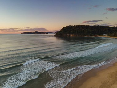 Denizin üzerinde gün doğumu Orta Sahildeki Umina Sahili, NSW, Avustralya.