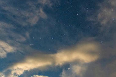 Port Stephens, NSW, Avustralya 'daki Tilligerry Deresi' nde bulutlar ve yıldızlarla dolu fırtınalı bir gece..