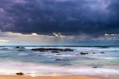 Central Coast, NSW, Avustralya 'daki Bateau Körfezi' nde bulutlar ve yağmurlu bir plaj gündoğumu.