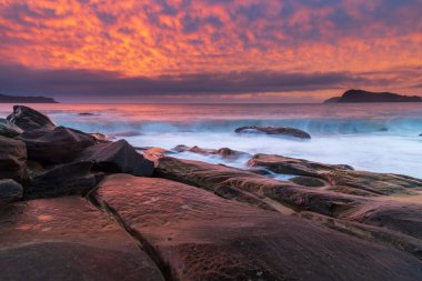 Central Coast, NSW, Avustralya 'daki Kuzey Pearl Sahili' nden yükselen bulutlu renkli gündoğumu deniz manzarası..