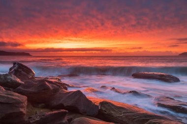 Central Coast, NSW, Avustralya 'daki Kuzey Pearl Sahili' nden yükselen bulutlu renkli gündoğumu deniz manzarası..