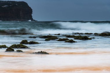Central Coast, NSW, Avustralya 'daki MacMasters Sahili' nde bulutlu bir gün doğumu..