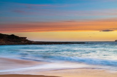 Central Coast, NSW, Avustralya 'daki Bouddi Ulusal Parkı' ndaki Putty Plajı 'nda deniz kenarında gün batımı.