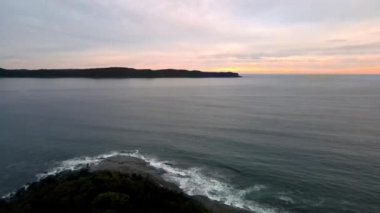 Central Coast, NSW, Avustralya 'daki Pearl Beach' ten yükselen bulutlu gündoğumu deniz manzaralı gökyüzü.