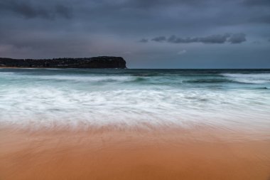Central Coast, NSW, Avustralya 'daki MacMasters Sahili' nde bulutlu bir gün doğumu..