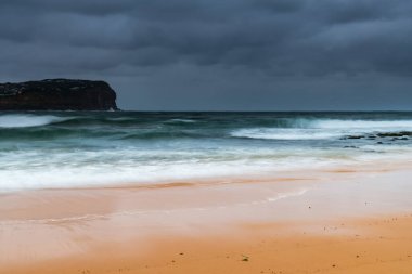 Central Coast, NSW, Avustralya 'daki MacMasters Sahili' nde bulutlu bir gün doğumu..
