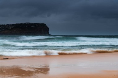 Central Coast, NSW, Avustralya 'daki MacMasters Sahili' nde bulutlu bir gün doğumu..