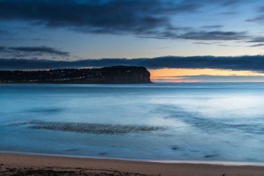 Bulutlarla, yosunlarla ve kayalarla şafak vakti deniz manzarası Central Coast, NSW, Avustralya 'daki MacMasters Sahili' nde..