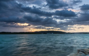 Fırtına bulutları, Avustralya, NSW 'deki Woy Woy rıhtımında gün doğumu su manzarası oluşturuyor..