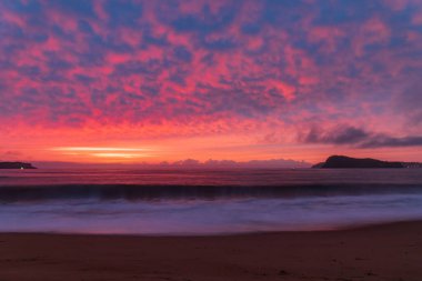 Central Coast, NSW, Avustralya 'daki Kuzey Pearl Sahili' nden yükselen bulutlu renkli gündoğumu deniz manzarası..
