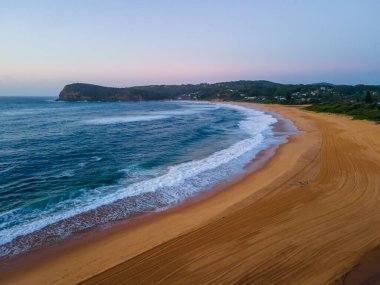 Sahil kenarında gün doğumu açık gökyüzü ve Copacabana sahilinde kum desenleri ile Central Coast, NSW, Avustralya.