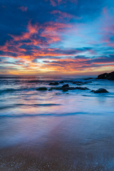Высокие облака над морем, синий, розовый и оранжевый восход солнца с пляжа Киллкэр на Центральном побережье, Новый Южный Уэльс, Австралия.