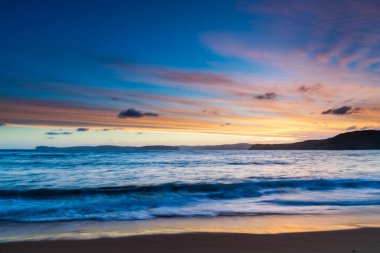 Central Coast, NSW, Avustralya 'daki Bouddi Ulusal Parkı' ndaki Putty Plajı 'nda deniz kenarında gün batımı.