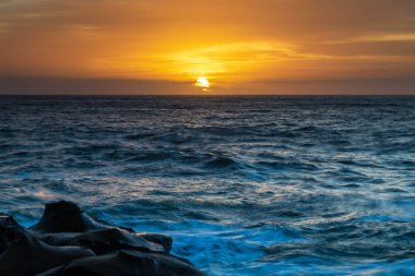Central Coast, NSW, Avustralya 'daki North Avoca Sahili' nde yüksek bulutlu ve tesselleştirilmiş kaya platformu ile renkli gündoğumu deniz manzarası.