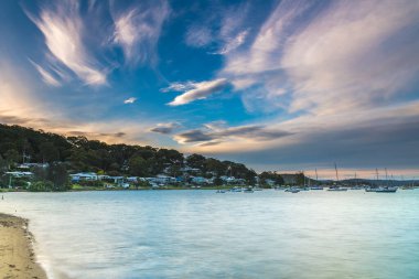 Avustralya, NSW 'nin merkez kıyısındaki Hardys Körfezi' nde tekne ve gün batımı..