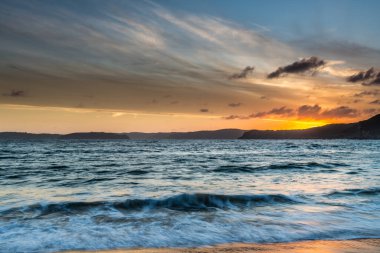 Central Coast, NSW, Avustralya 'daki Bouddi Ulusal Parkı' ndaki Putty Plajı 'nda deniz kenarında gün batımı.
