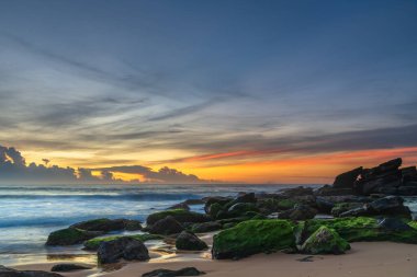 Ufuktaki bir bulut kümesi üzerinde yüksek bulutlar sürükleniyor. Central Coast, NSW, Avustralya 'daki Killcare Sahili' nden gündoğumu deniz manzarası..