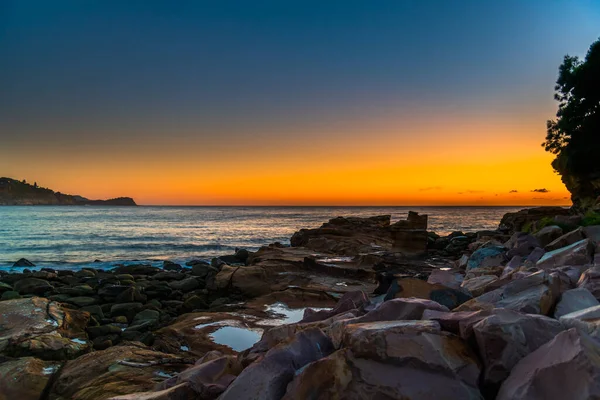 Sunrise seascape and rock pool at Avoca Beach on the Central Coast, NSW, Australia.