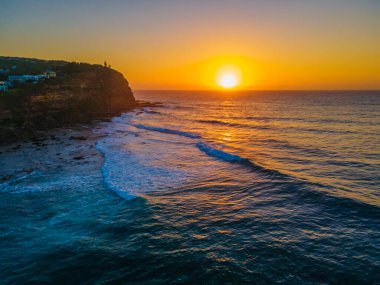 Sahil kenarında gün doğumu açık gökyüzü ve Copacabana sahilinde kum desenleri ile Central Coast, NSW, Avustralya.