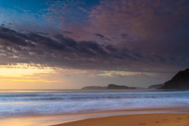 Gündoğumu renkleriyle kumsalda geçen sonbahar günleri Umina Sahili 'nde, NSW, Avustralya.