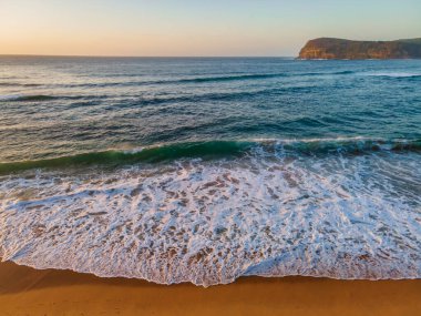 Sahil kenarında gün doğumu açık gökyüzü ve Copacabana sahilinde kum desenleri ile Central Coast, NSW, Avustralya.