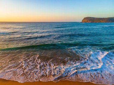 Sahil kenarında gün doğumu açık gökyüzü ve Copacabana sahilinde kum desenleri ile Central Coast, NSW, Avustralya.