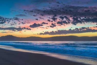 Gündoğumu renkleriyle kumsalda geçen sonbahar günleri Umina Sahili 'nde, NSW, Avustralya.