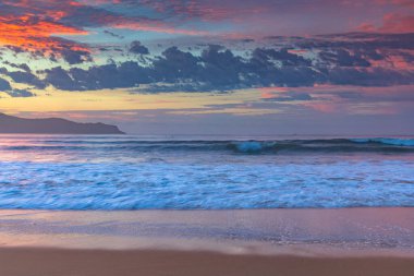 Gündoğumu renkleriyle kumsalda geçen sonbahar günleri Umina Sahili 'nde, NSW, Avustralya.