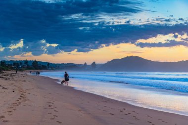Gündoğumu renkleriyle kumsalda geçen sonbahar günleri Umina Sahili 'nde, NSW, Avustralya.