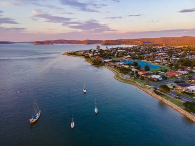 Gündoğumu uçağı Ettalong Sahili 'nden NSW, Avustralya' ya doğru uçuyor..