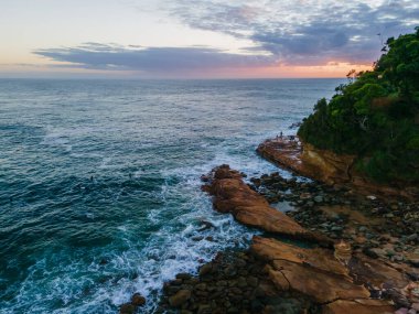 Central Coast, NSW, Avustralya 'daki Avoca Sahili' nde sörfçülerle yaz gündoğumu deniz manzarası.