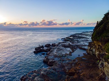 Gündoğumu deniz manzarası ve kayalık burunlar Avoca Sahili 'nden Orta Sahile, NSW, Avustralya.