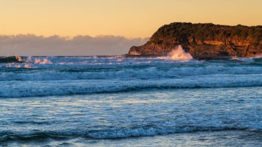 Avustralya, NSW 'nin merkez kıyısındaki Munmorah Eyalet Rekreasyon Bölgesi' nde yer alan Frazer Sahili 'nde güneş doğuyor..