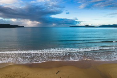 Central Coast, NSW, Avustralya 'daki Umina Sahili' ndeki Ocean Beach 'te Bulutlu Hava Gündoğumu Deniz Burnu.