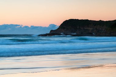 Avustralya, NSW 'nin merkez kıyısındaki Munmorah Eyalet Rekreasyon Bölgesi' nde yer alan Frazer Sahili 'nde güneş doğuyor..