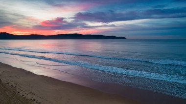 Hava Kış Gündoğumu Deniz Pelerini Orta Sahildeki Umina Sahili 'nde bulutlu, NSW, Avustralya.
