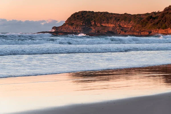 Avustralya, NSW 'nin merkez kıyısındaki Munmorah Eyalet Rekreasyon Bölgesi' nde yer alan Frazer Sahili 'nde güneş doğuyor..