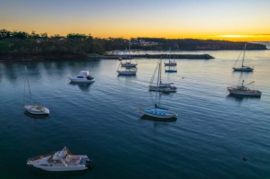 Avustralya, NSW 'nin güney kıyısındaki Ulladulla Limanı' nda teknelerle Sunrise Waterscape