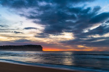 Orta Sahildeki MacMasters Sahili 'nden gelen yüksek bulutlu gündoğumu denizi, NSW, Avustralya.