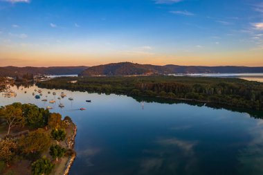Brisbane Suları üzerindeki bulutlu hava gündoğumu manzarası. Woy Woy 'daki Merkez Sahili, NSW, Avustralya..